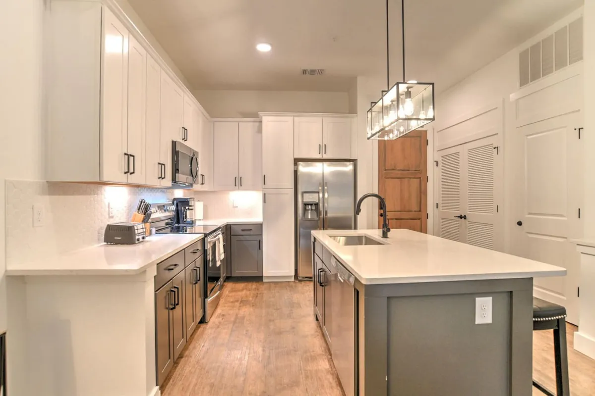 This image spotlights a functional and welcoming kitchen with a central island, stainless steel appliances, and plenty of cabinetry. The space hints at social gatherings or a quick breakfast before exploring the city, reinforcing convenience for the solo traveler.